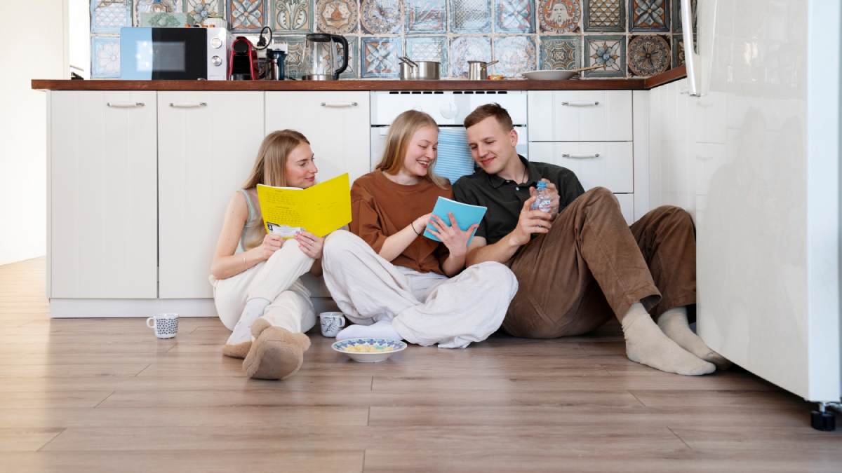Happy family sitting on the laminate floor in the kitchen